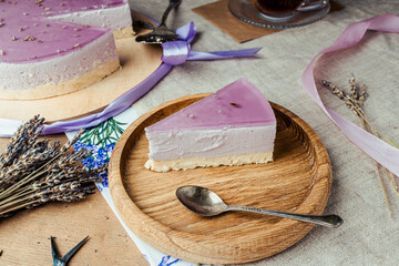 lavender cheesecake on shortcrust pastry with purple jelly in a rustic style cut with tea in a...