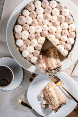 Kyiv cake with nuts, buttercream on a white cake pan in a cut on a white plate, espresso coffee, gold cutlery, Ukrainian desserts, nut cake, flatlay