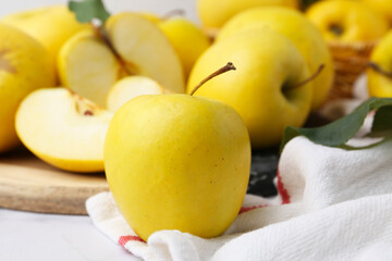 Whole and cut ripe yellow apples on table, closeup