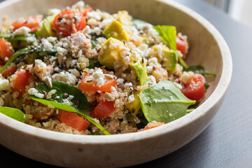Close-up of a vibrant and nutritious salad made with quinoa, avocado, mixed seeds, and cheese, packed with protein and healthy fats for a wholesome meal