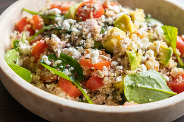 Close-up of a vibrant and nutritious salad made with quinoa, avocado, mixed seeds, and cheese, packed with protein and healthy fats for a wholesome meal