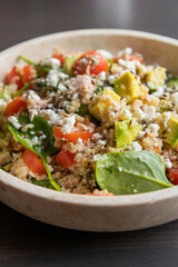 Close-up of a vibrant and nutritious salad made with quinoa, avocado, mixed seeds, and cheese, packed with protein and healthy fats for a wholesome meal