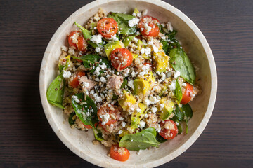 Close-up of a vibrant and nutritious salad made with quinoa, avocado, mixed seeds, and cheese, packed with protein and healthy fats for a wholesome meal