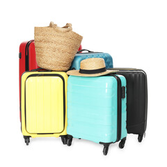 Many colorful suitcases, beach bag and straw hat isolated on white