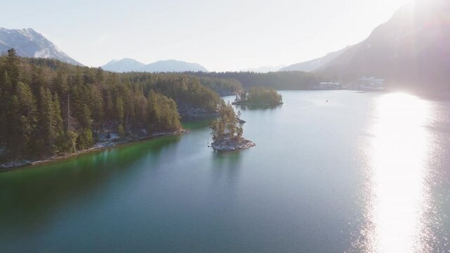 Pan left during sunrise at the magnificent Eibsee lake and incredible snowy mountains background, Bavaria; Germany.