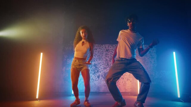 Full-length portrait of couple of black dancers performing dancehall on stage. African American man and woman enjoying rhythm of ethnic music and dancing, modern choreographic sequences and music