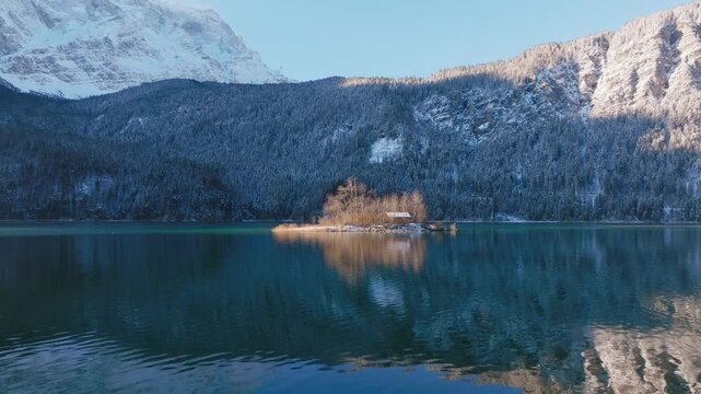 Traveling in front of Lake Eibsee of a small building on a small island, Bavaria; Germany.