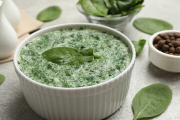 Delicious spinach sauce served on grey table, closeup