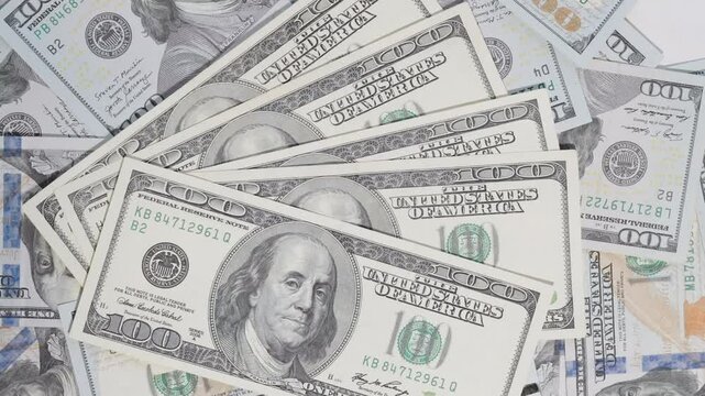 A stack of old hundred-dollar bills placed atop newer ones, with a spinning motion that contrasts the vintage and modern designs, emphasizing the evolution of currency.