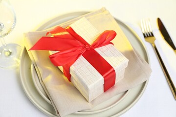 Gift and setting for romantic dinner on white background, closeup