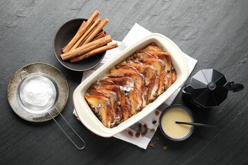 Flat lay composition with freshly baked bread pudding on dark textured table