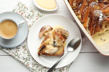 Freshly baked bread pudding and coffee on white wooden table, flat lay