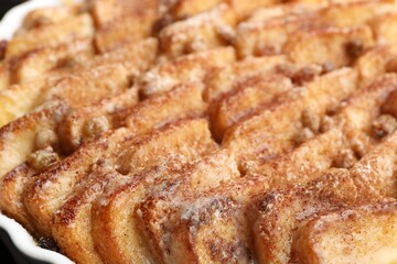 Delicious bread pudding with raisins and cinnamon in dish, closeup