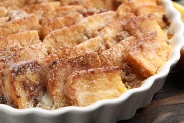 Delicious bread pudding with raisins and cinnamon on wooden table, closeup