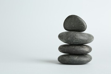 Stack of rocks on light background, space for text. Harmony and life balance