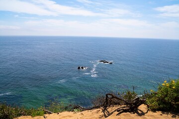 Scenic ocean view from a cliff with clear skies.
