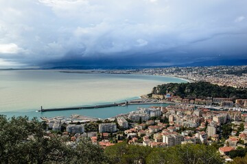 Naklejka premium Aerial view of Nice, France with coastal cityscape, harbor, and cloudy sky.