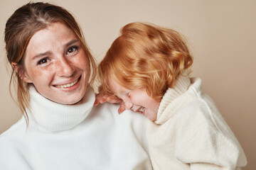 Family portrait of mother and daughter in stylish white outfits at a fashionable photoshoot event