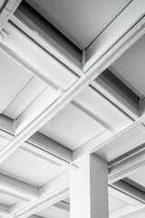 Obraz premium White ceiling grid with beams and vertical column.