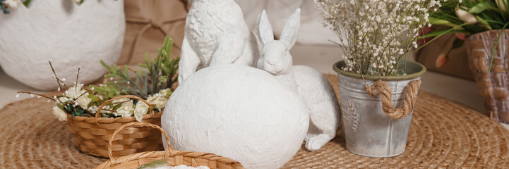 Interior floral Easter composition. Figurines of Easter bunnies and a large eggshell.
