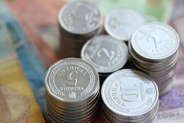 Few stacks of ukrainian money coins lies on old hryvnia banknotes