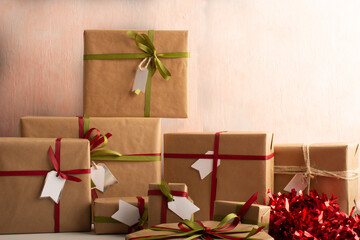 set of gifts wrapped in craft paper and colored ribbons, white labels.