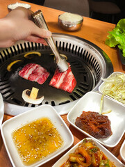 Korean restaurant. Korean barbecue, roasting marbled beef over a fire in the middle of the table....