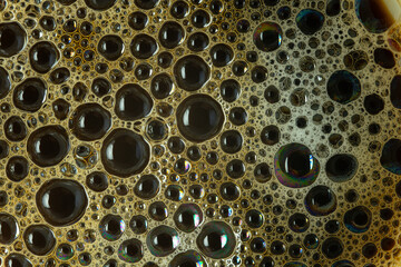 Close up of a cup of black coffee. Milk in coffee close-up top view. Black coffee with milk cream foam texture. Coffee foam macro.