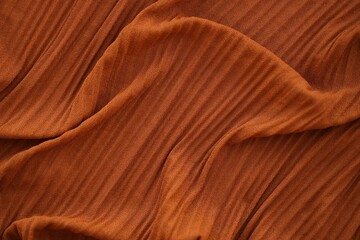 Bright orange fabric background from a piece of crumpled clothes