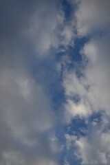 rays of the sun through cirrus clouds against a blue sky, white rainy clouds against a blue sky illuminated by the rays of the sun	
