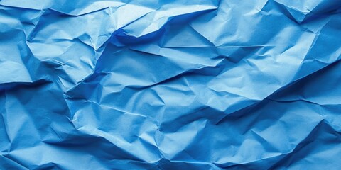 Obraz premium Crumpled blue paper texture with varying shades of blue throughout the folds creating depth and visual interest in an abstract design.