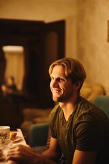 Portrait of a young caucasian man smiling and having a festive dinner in the kitchen