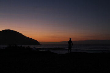 Obraz premium silhueta de homem em nascer do sol na praia 