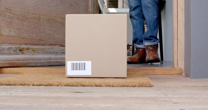 Receiving package, person standing at doorstep holding cardboard box