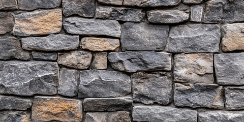 Obraz premium Grey and brown stone wall texture featuring rustic stones in varying sizes arranged tightly, ideal for wallpaper backgrounds and interior designs.