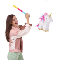 Happy woman breaking unicorn shaped pinata with stick isolated on white