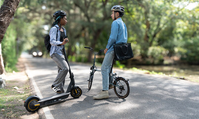 Commuting to work with bicycle. Young business person cycling and riding electric scooter to office in downtown district. Modern diversity people use eco transportation in city. Sustainable lifestyle.
