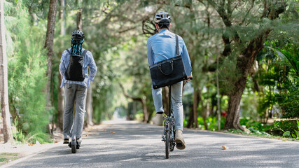 Commuting to work with bicycle. Young business person cycling and riding electric scooter to office in downtown district. Modern diversity people use eco transportation in city. Sustainable lifestyle.