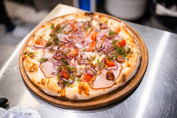 homemade fresh pizza with homemade sausage, ham, cheese sauce, dill, onion, French mustard, freshly baked pizza in the bakery, lunch