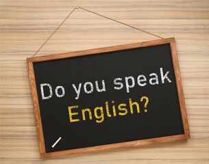 Obraz premium Small black chalkboard with text Do You Speak English? on wooden background. Language course