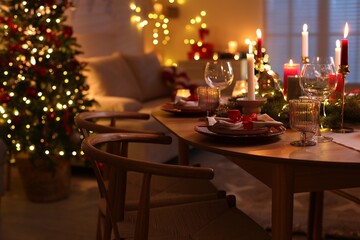 Festive table setting in room decorated for Christmas. Bokeh effect