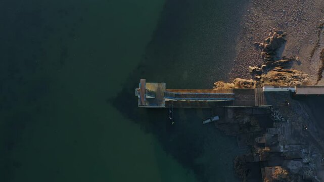 Ascending aerial top-down shot of Salthill diving board at sunset. Galway, Ireland