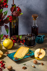 Gourmet cheese with quince, walnuts, and wine pairing on rustic table setting