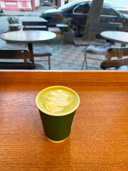 Inviting green beverage sits on wooden table in cozy cafe during a serene morning