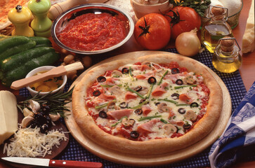 Ham olive pizza and kitchen ingredients.