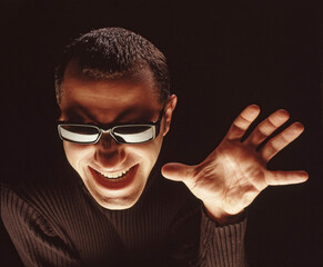 Scare villain face man hand open on black background.