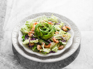 salad with shrimp, cheese and avocado on a marble background