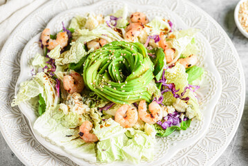 salad with shrimp, cheese and avocado on a marble background