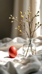 Fototapeta premium Minimalist still life with red egg and glass vase on sunlit fabric