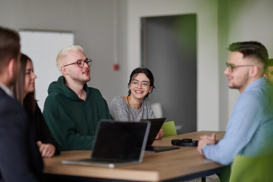 A diverse multiethnic business team engages in a collaborative meeting, discussing strategies and solutions in a modern office setting